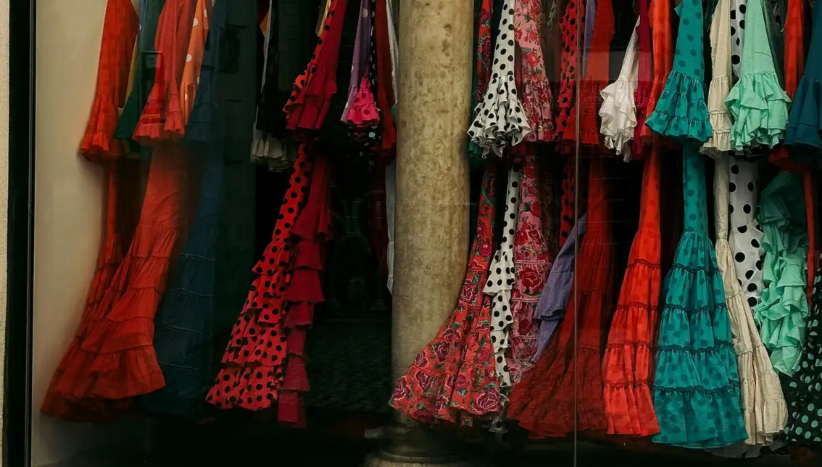 Rows of polka-dot flamenco dresses hanging in a Seville shop window
