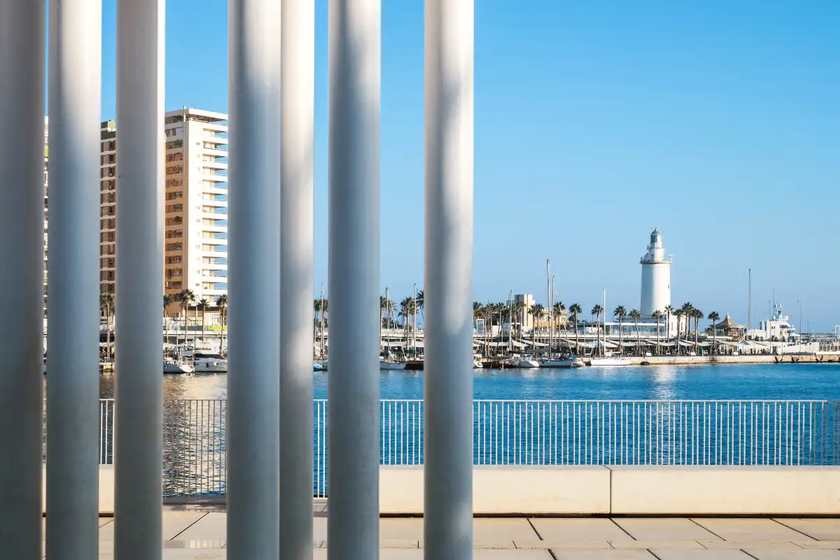 View of Málaga port and lighthouse from Muelle Uno on a clear day