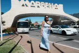 heidi walking under the marbell sign