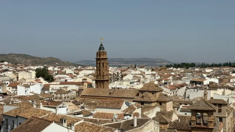 View over Antequera old town rooftops with the church bell tower and hills beyond