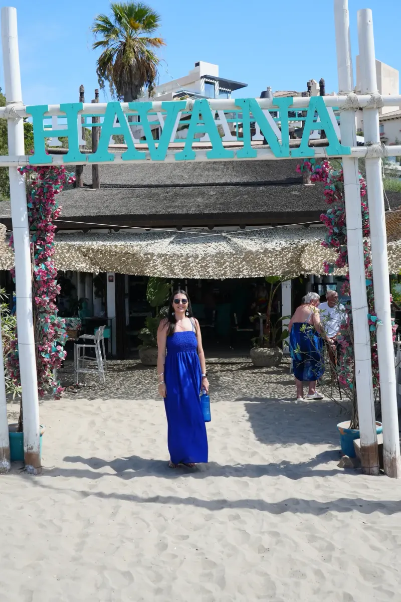 Heidi standing on the sand under the Havana sign at Havana Beach Club, Playa del Cristo, Estepona