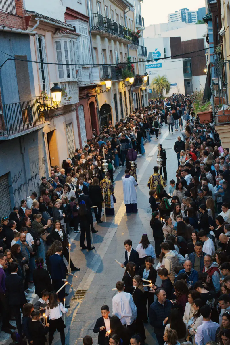 Candlelit Semana Santa procession moving through a narrow Málaga street at night