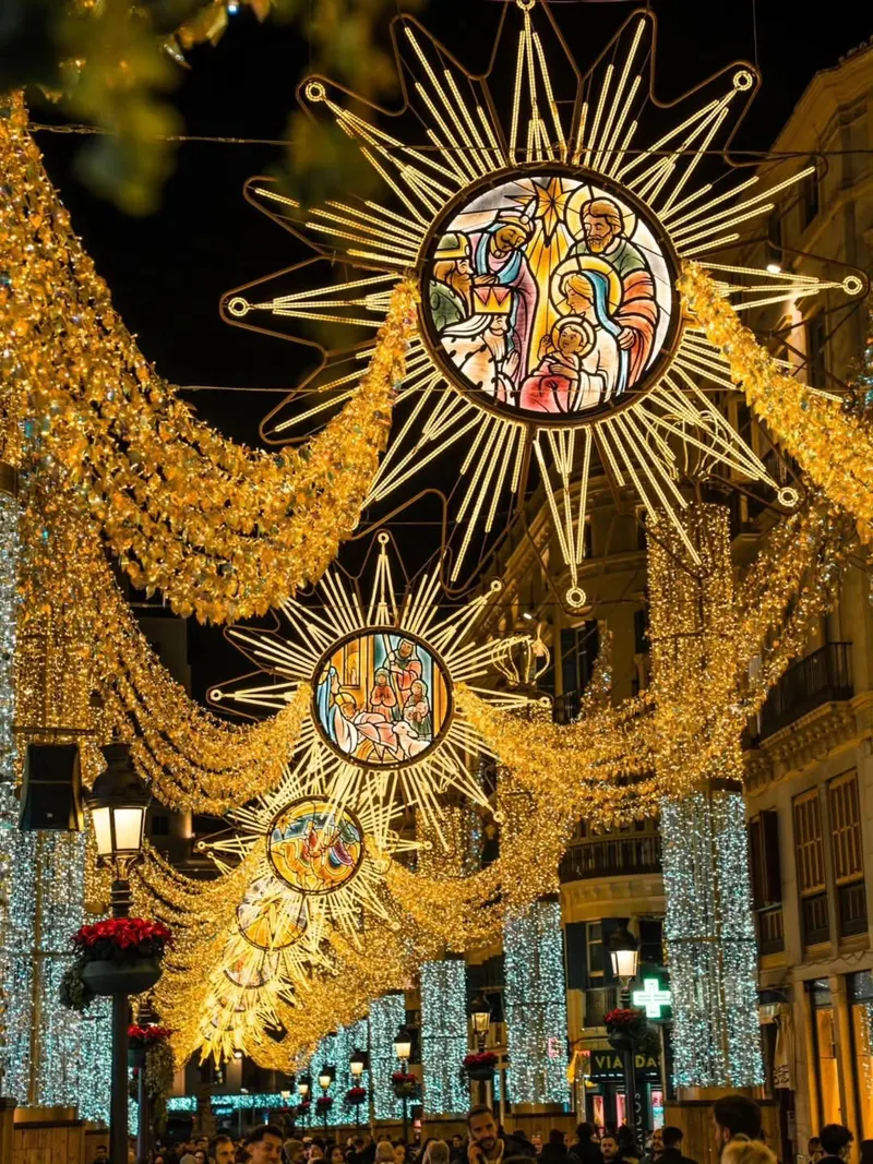 Golden nativity-star Christmas lights arching over Calle Larios in Malaga at night