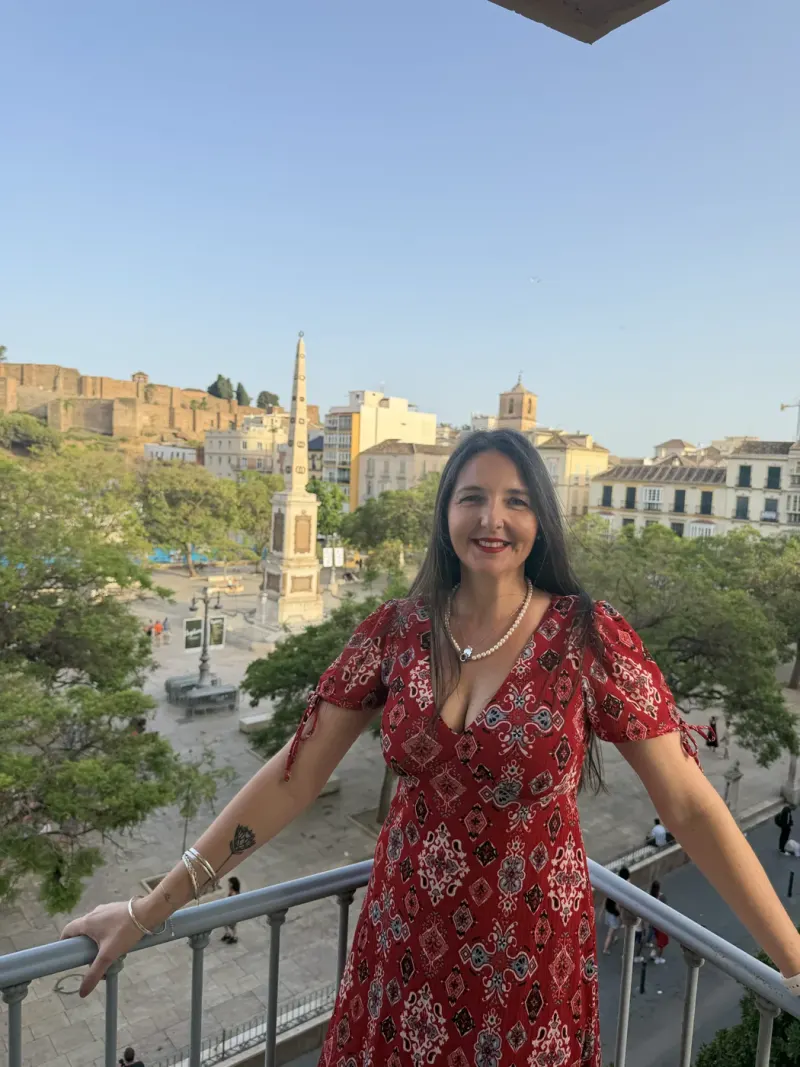 Heidi smiling on a balcony above Plaza de la Merced in Málaga