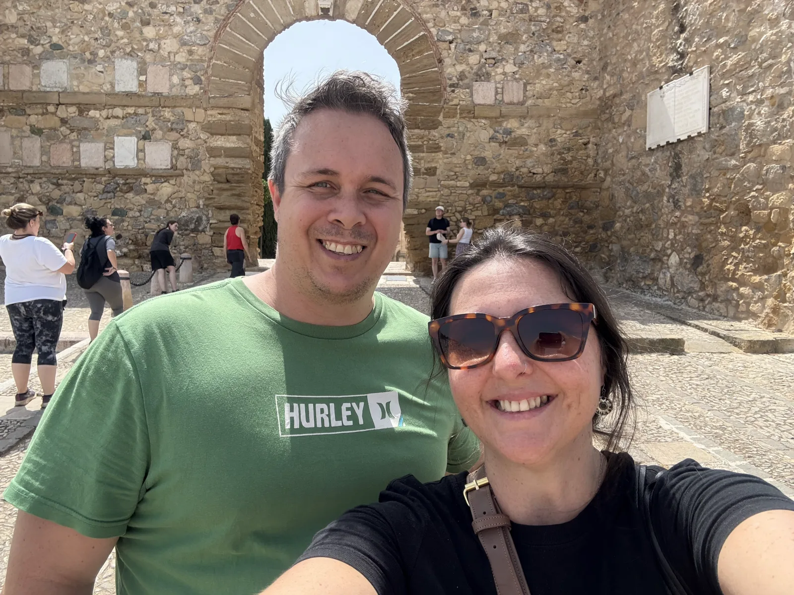 Heidi and Jethro taking a selfie in front of the stone Arco de los Gigantes in Antequera
