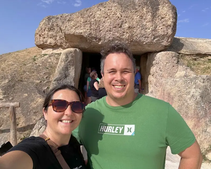 a couple stadning outside the dolmen cave in antequera