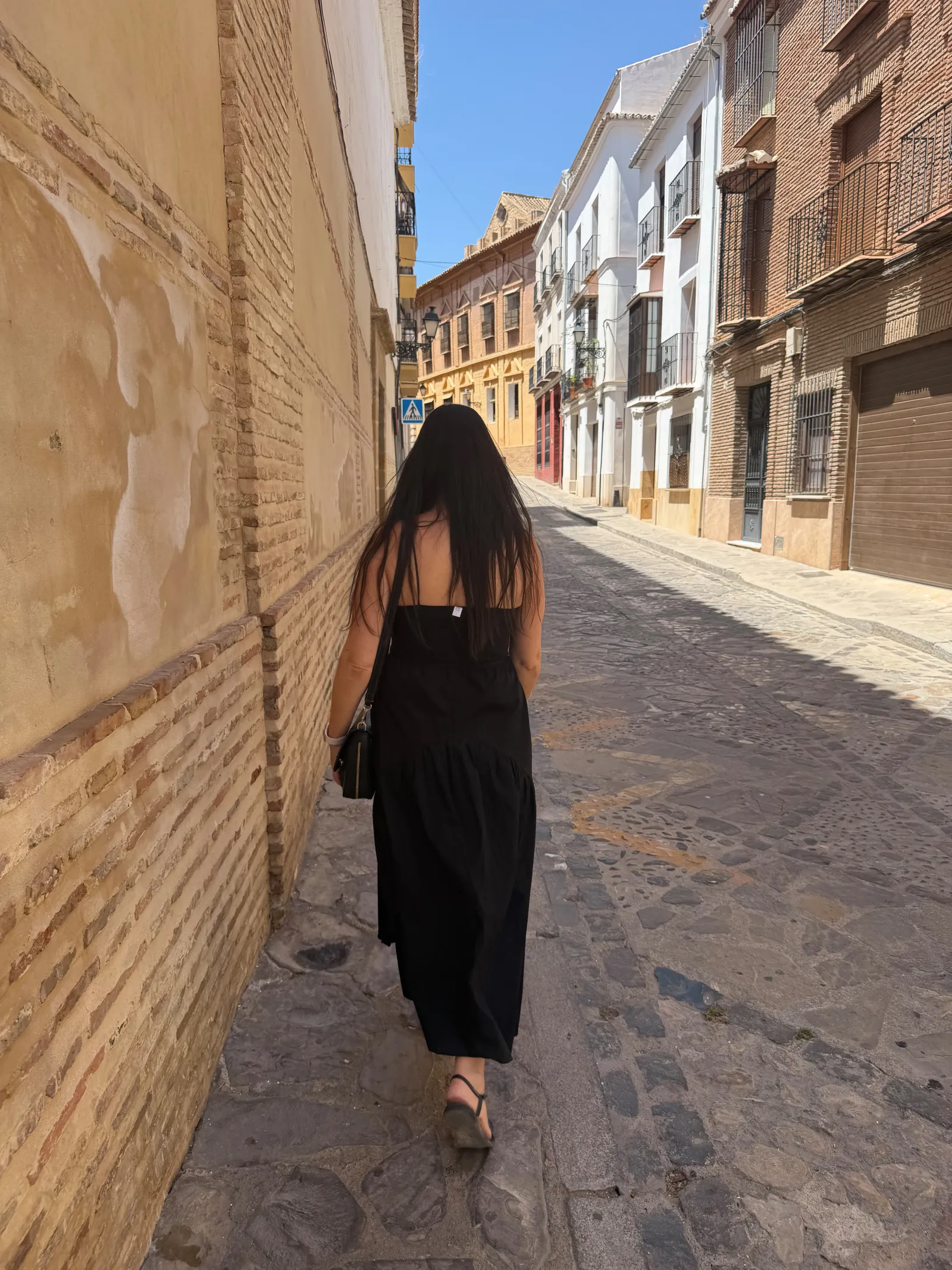 Heidi walking down a narrow old-town street in Antequera