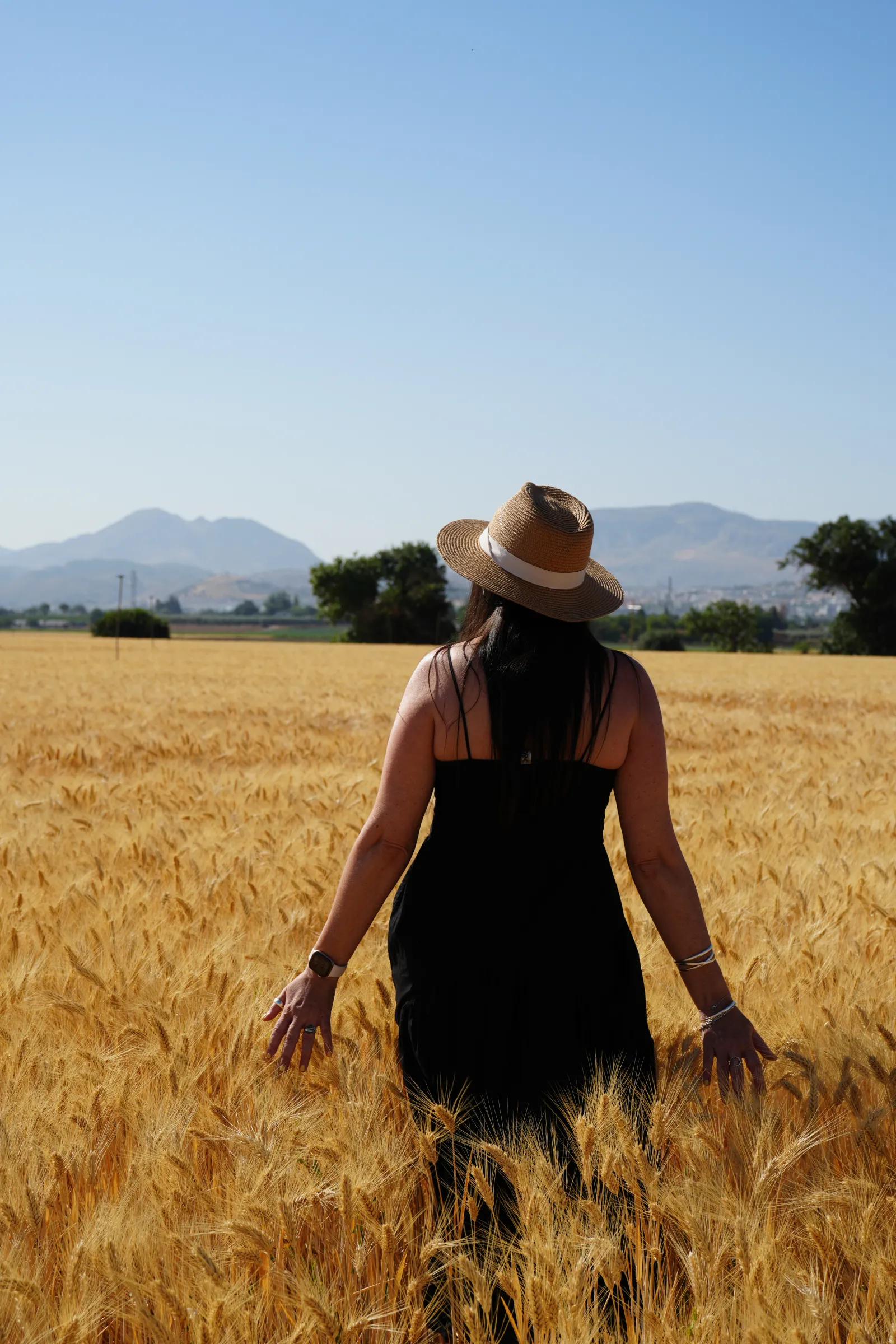 Heidi walking through a wheat field near Antequera