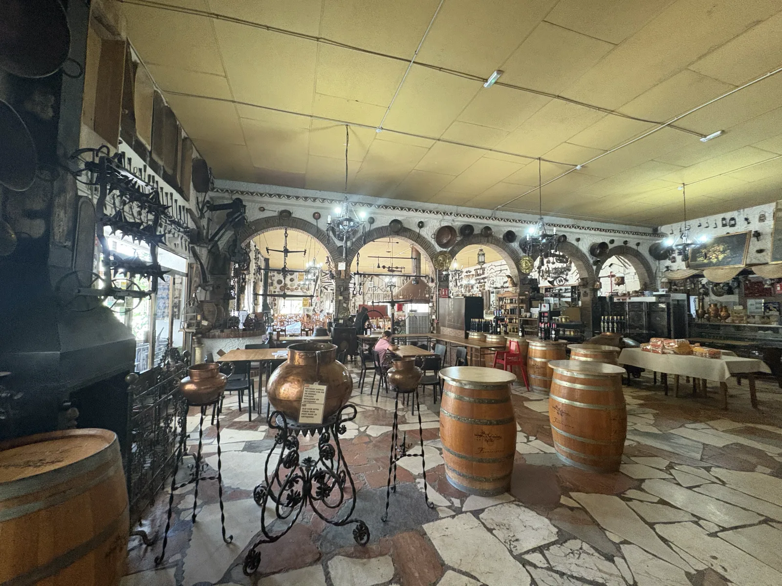 The museum-like interior of Molino Blanco restaurant near Antequera, filled with wine barrels, copper pots and antique farm tools