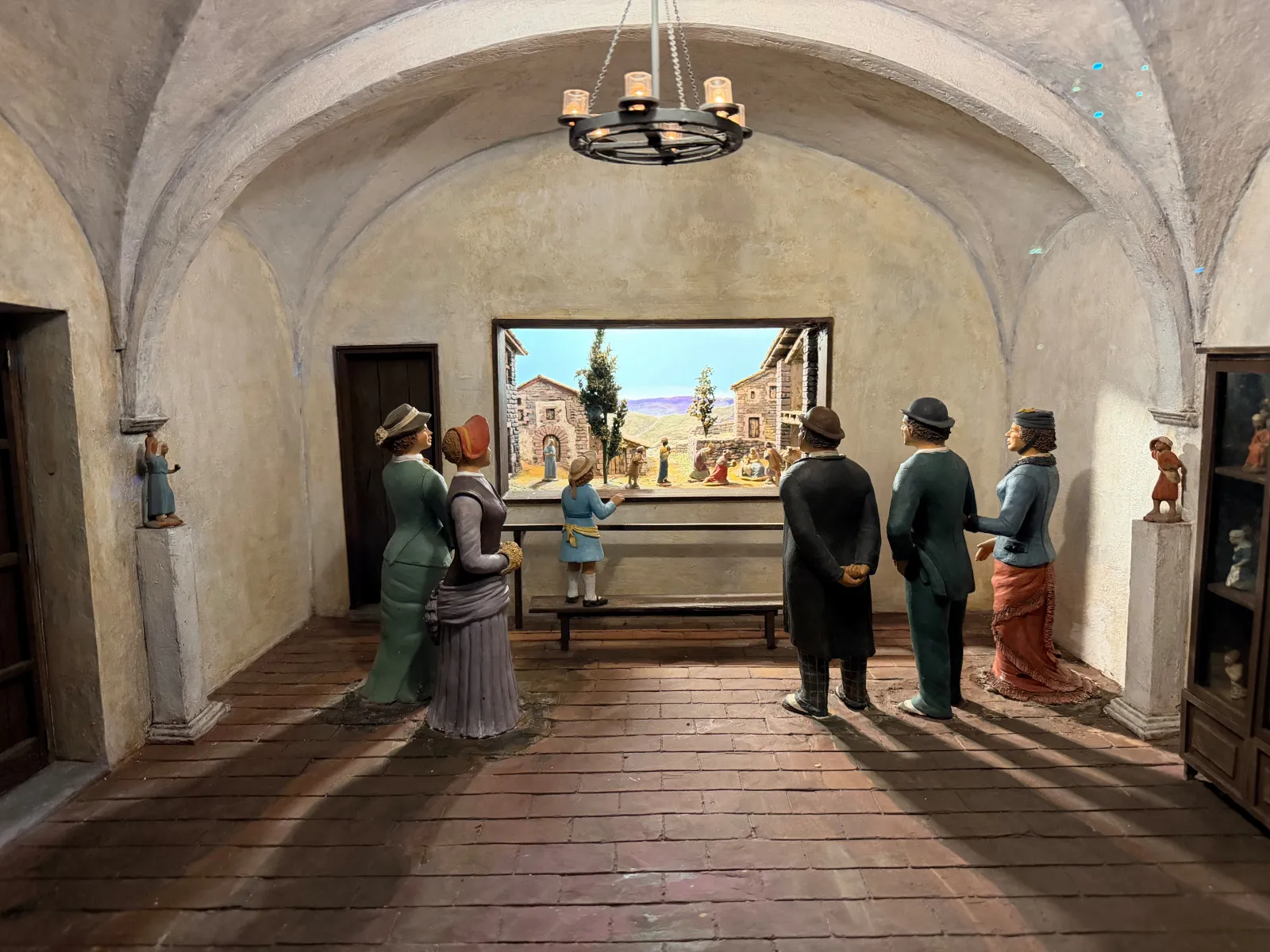 Visitors admiring a large painted nativity backdrop in a gallery at the museum