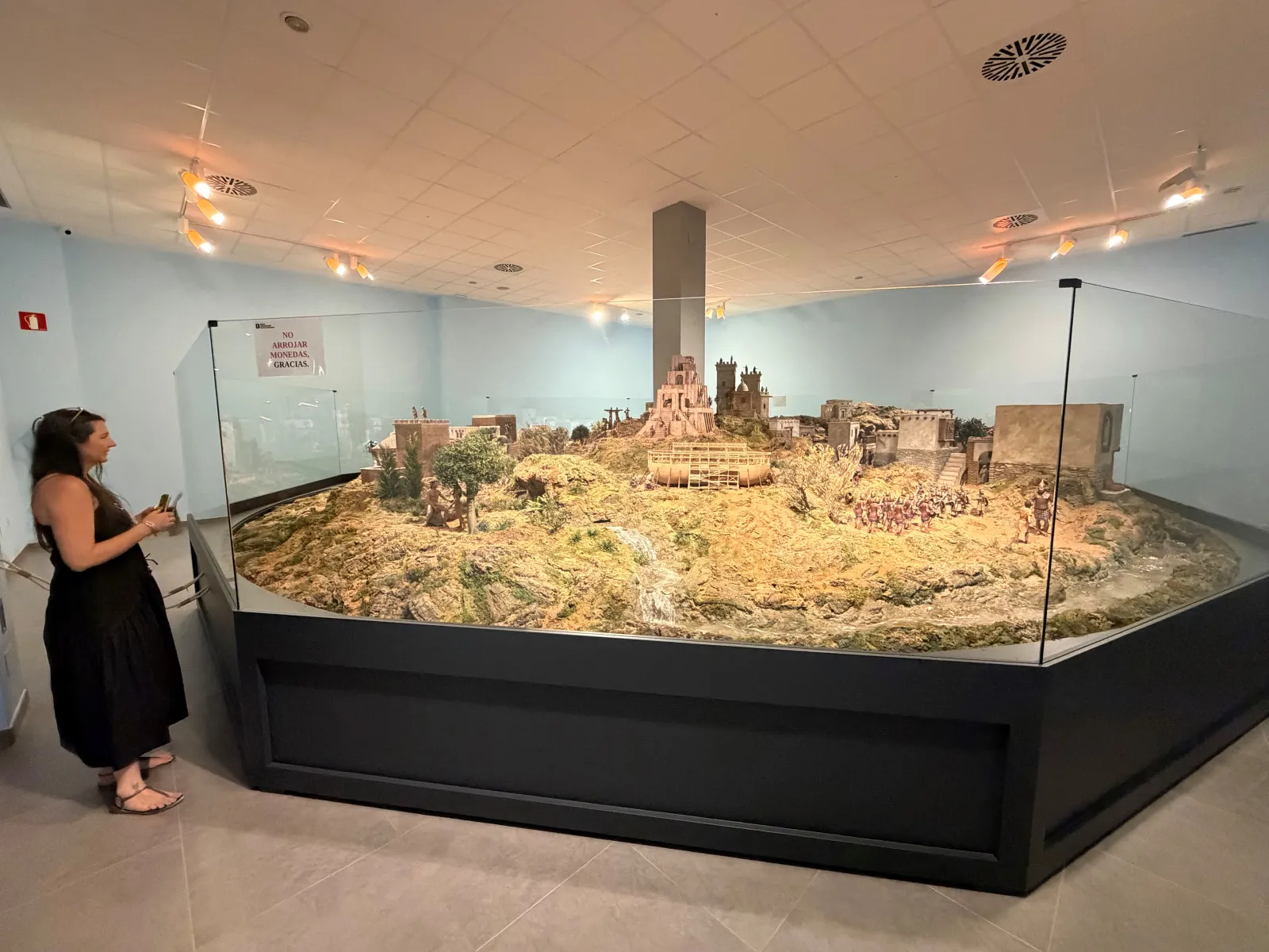 Heidi looking at a large detailed nativity diorama at the museum in Mollina