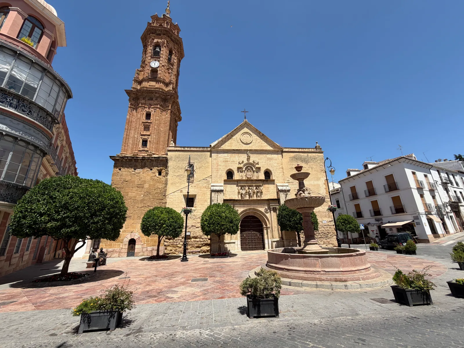 Plaza de San Sebastián in Antequera with its fountain, trees and the brick bell tower of the Iglesia de San Sebastián