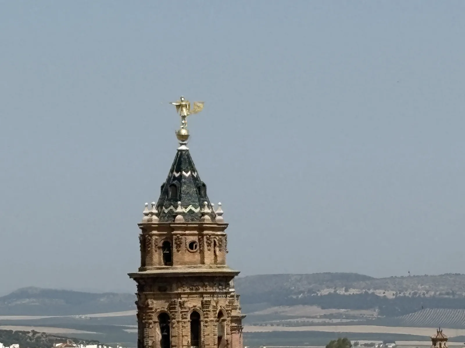 The golden angel weathervane atop the bell tower of the Iglesia de San Sebastián in Antequera