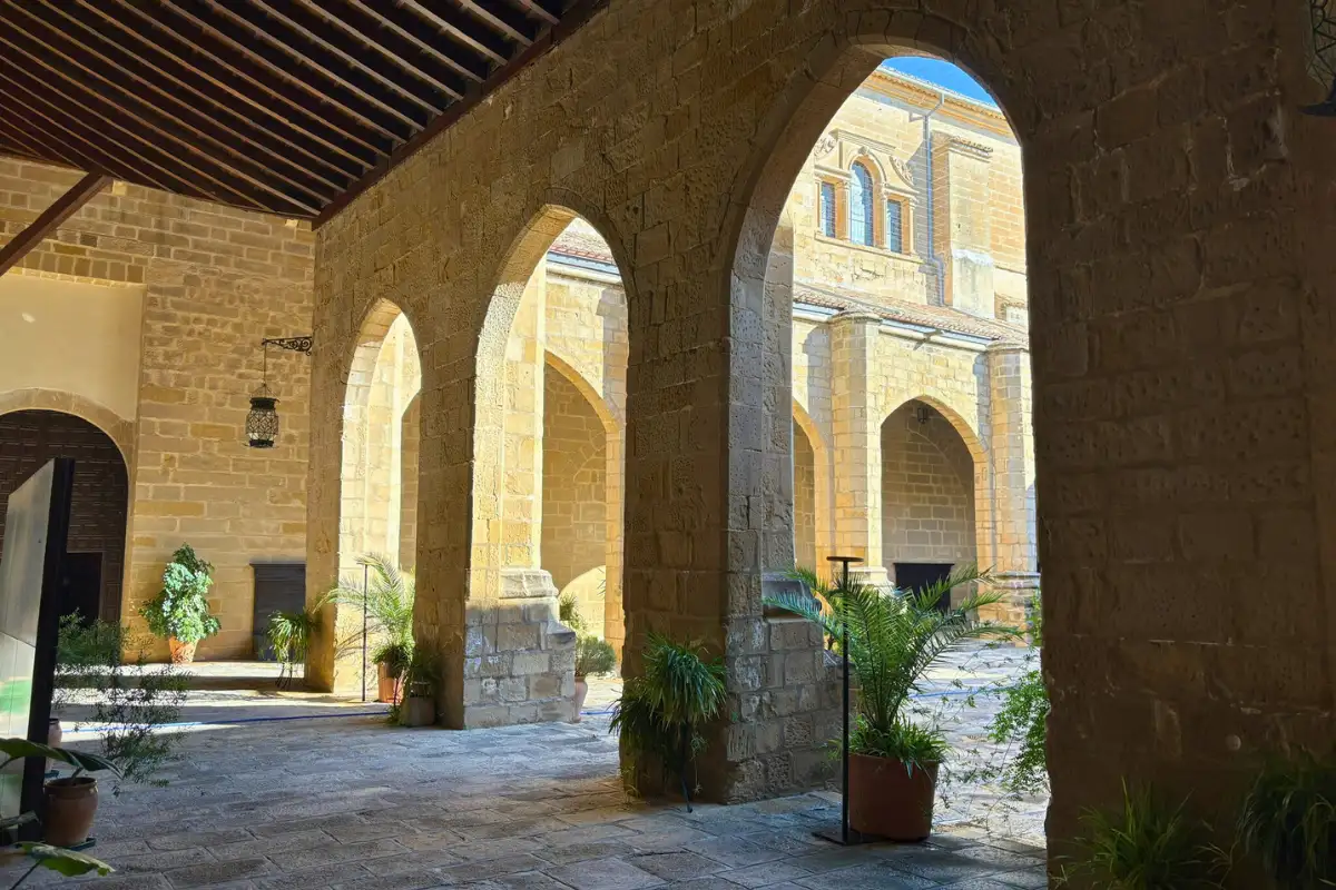 Stone arches and sunlit courtyard inside a historic Renaissance building in Baeza