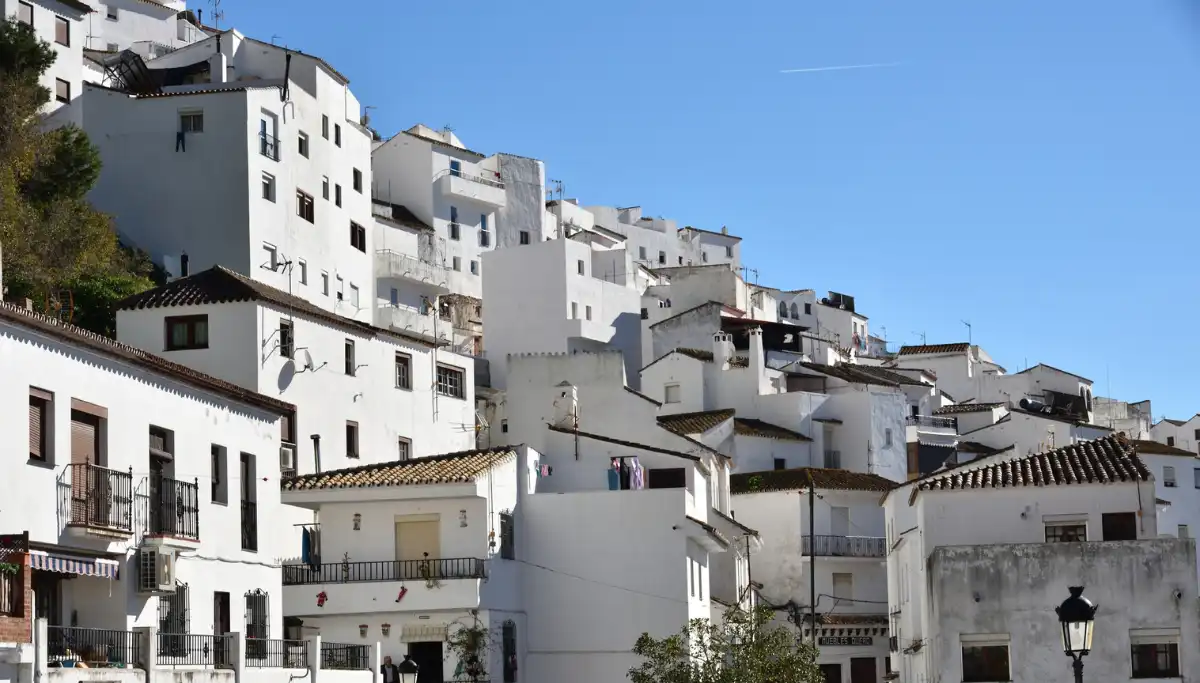 Casares white village houses clinging to a steep hillside with a ruined castle above