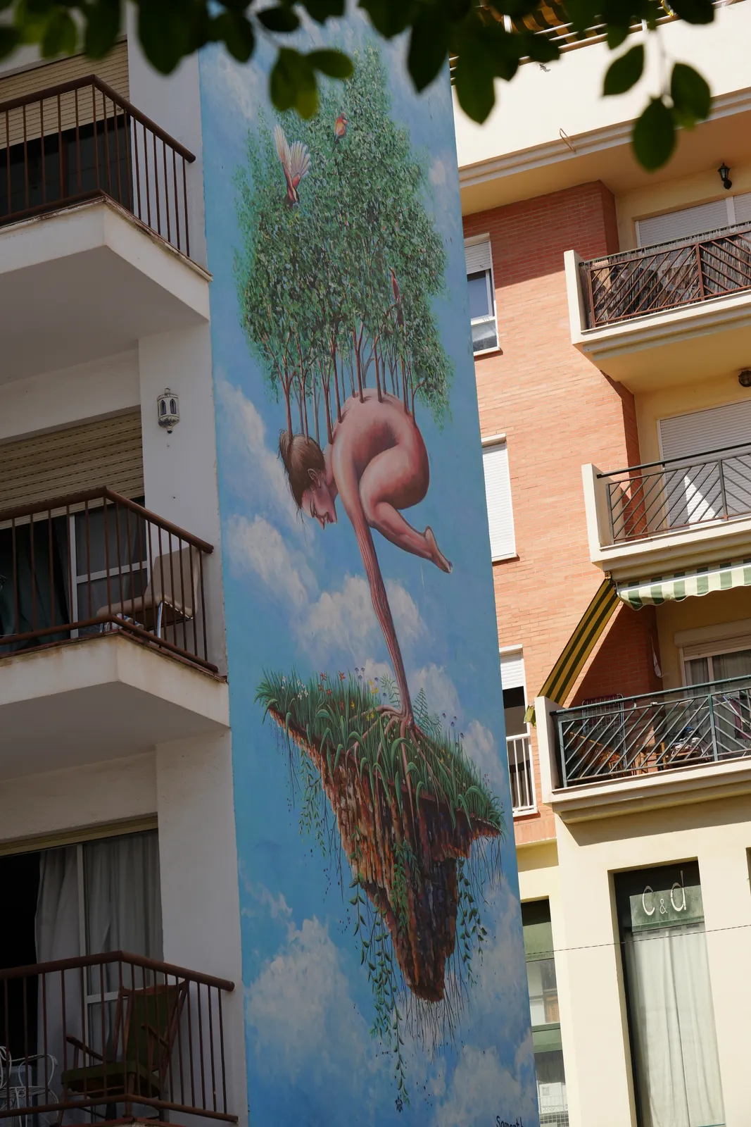 Surreal mural of a diver transforming into a floating island in Estepona
