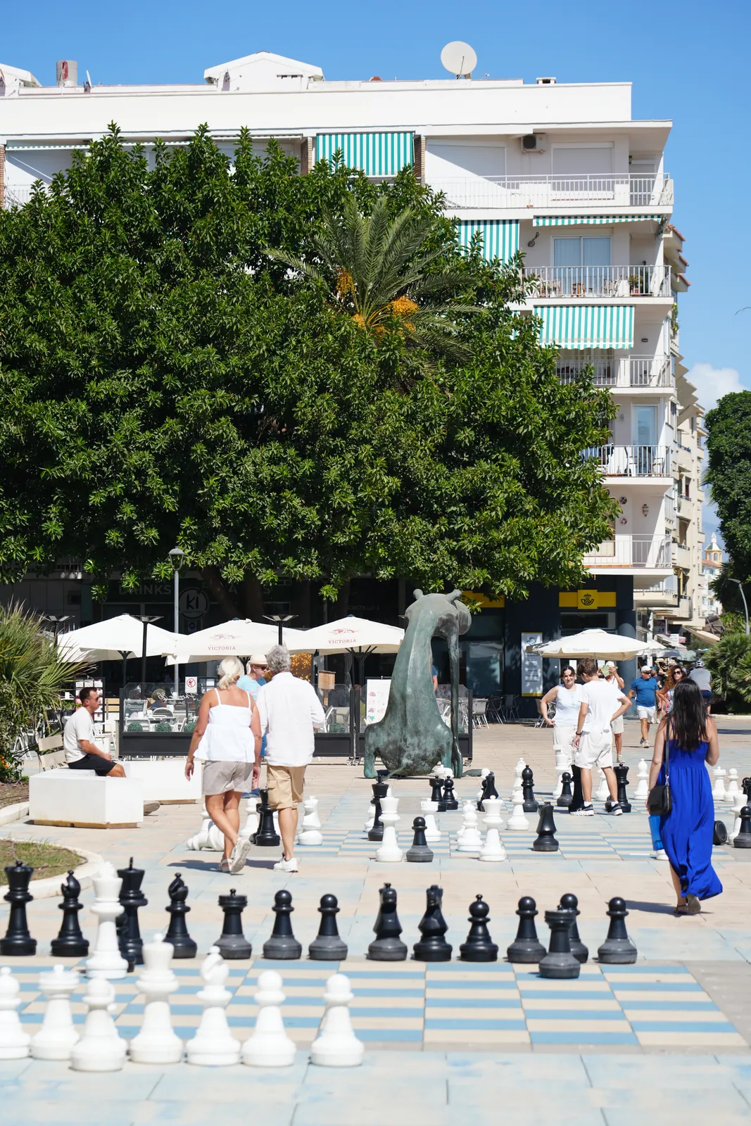 Full-scale chess pieces set into the tiled paving of Plaza del Ajedrez on Estepona's seafront promenade