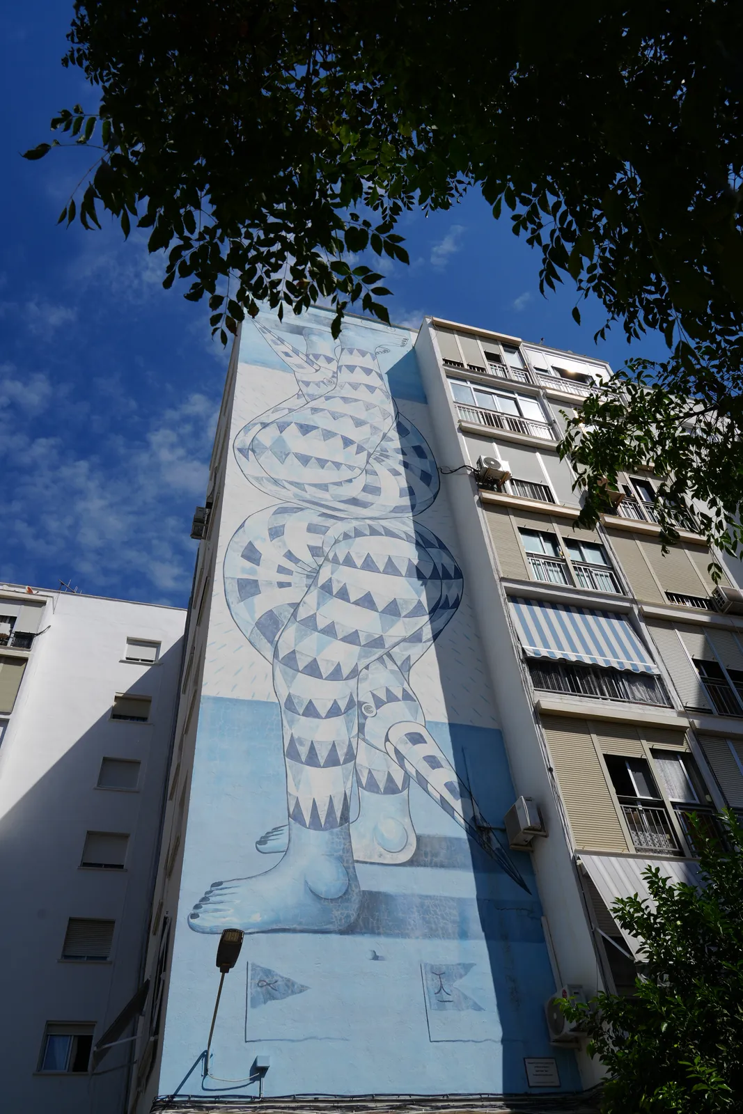 Winged figure mural made of blue and white triangles in Estepona