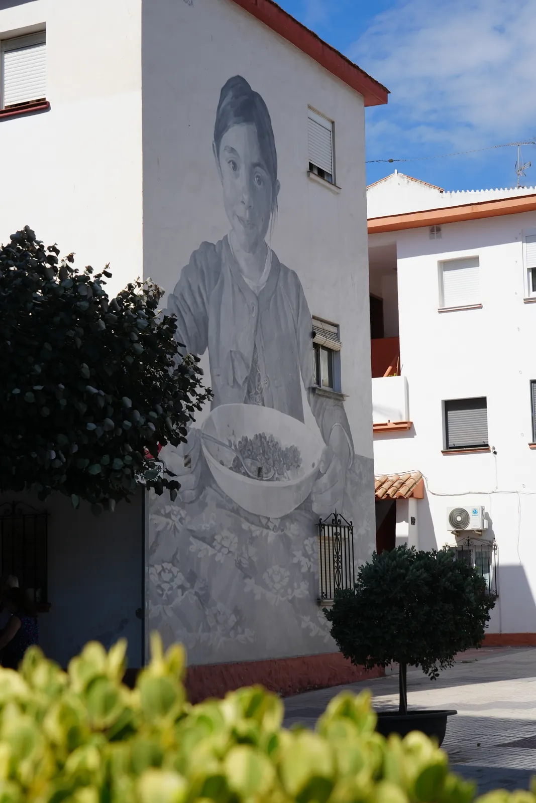 Girl holding a bowl of olives mural in Estepona