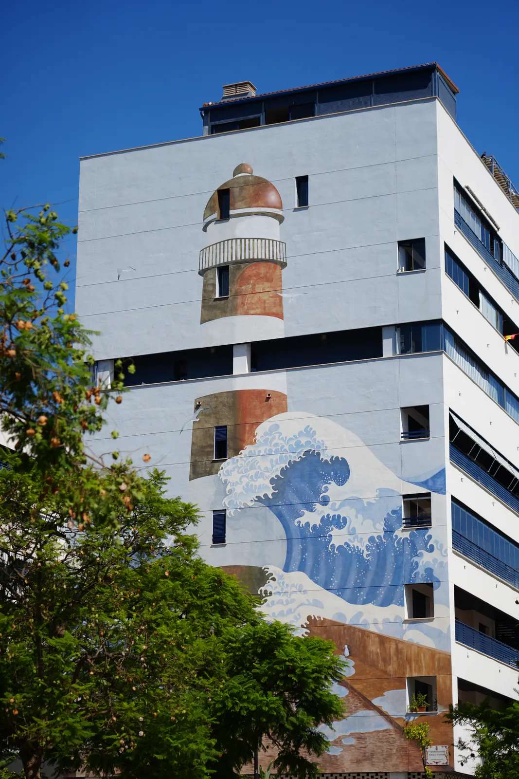 Lighthouse and Hokusai-style great wave mural covering the full height of a building in Estepona