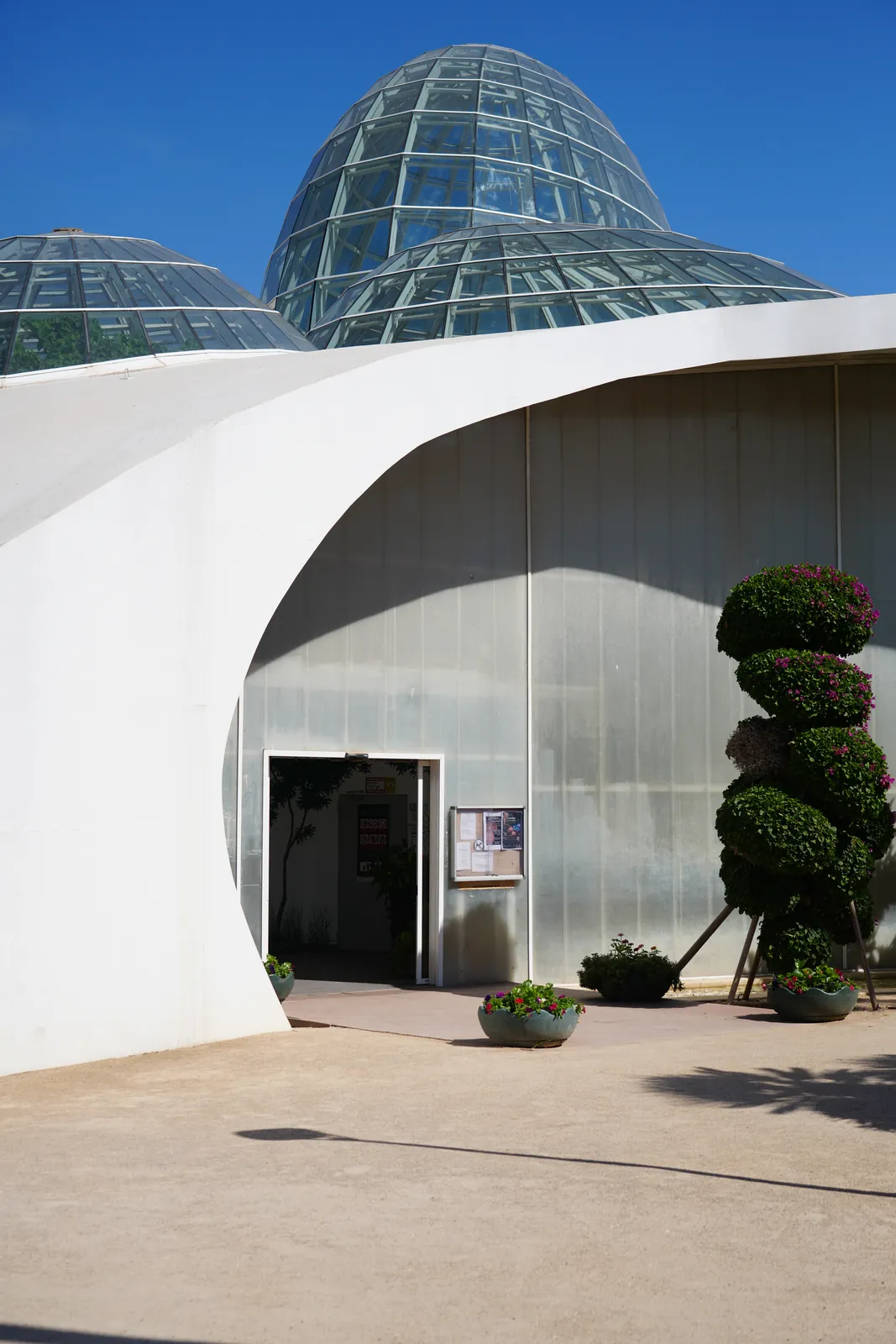 Two glass domes on a curved white building at Estepona's Orchidarium