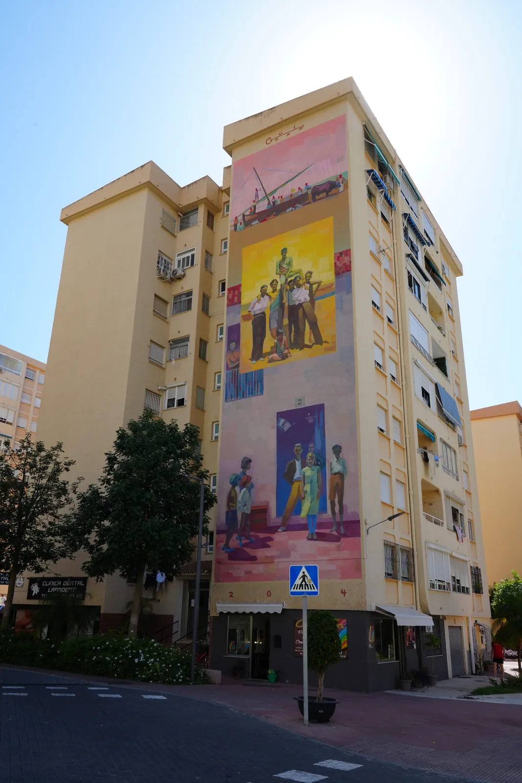 Three-panel apartment tower mural marking three building entrances in Estepona