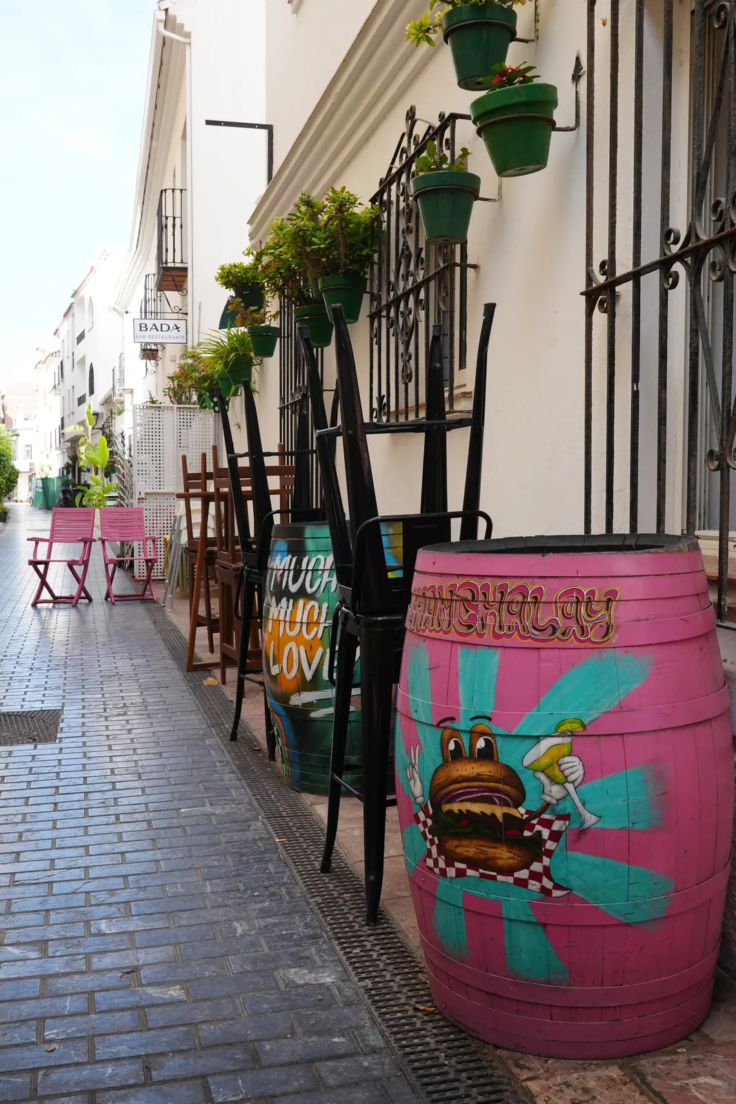 Repainted wine barrels used as street decor outside a bar in Estepona old town