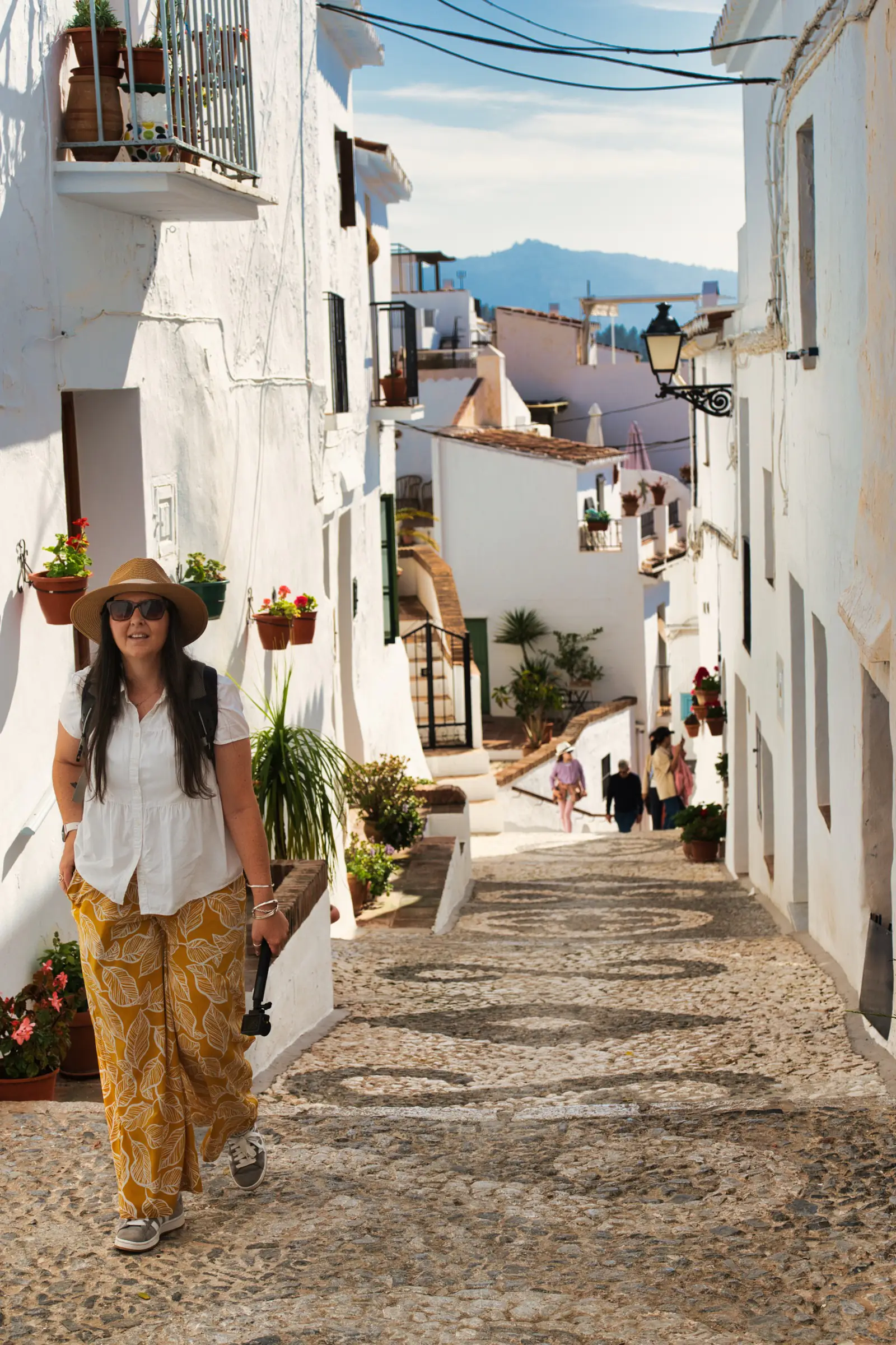 Heidi facing the camera in a cobbled whitewashed alley in Frigiliana