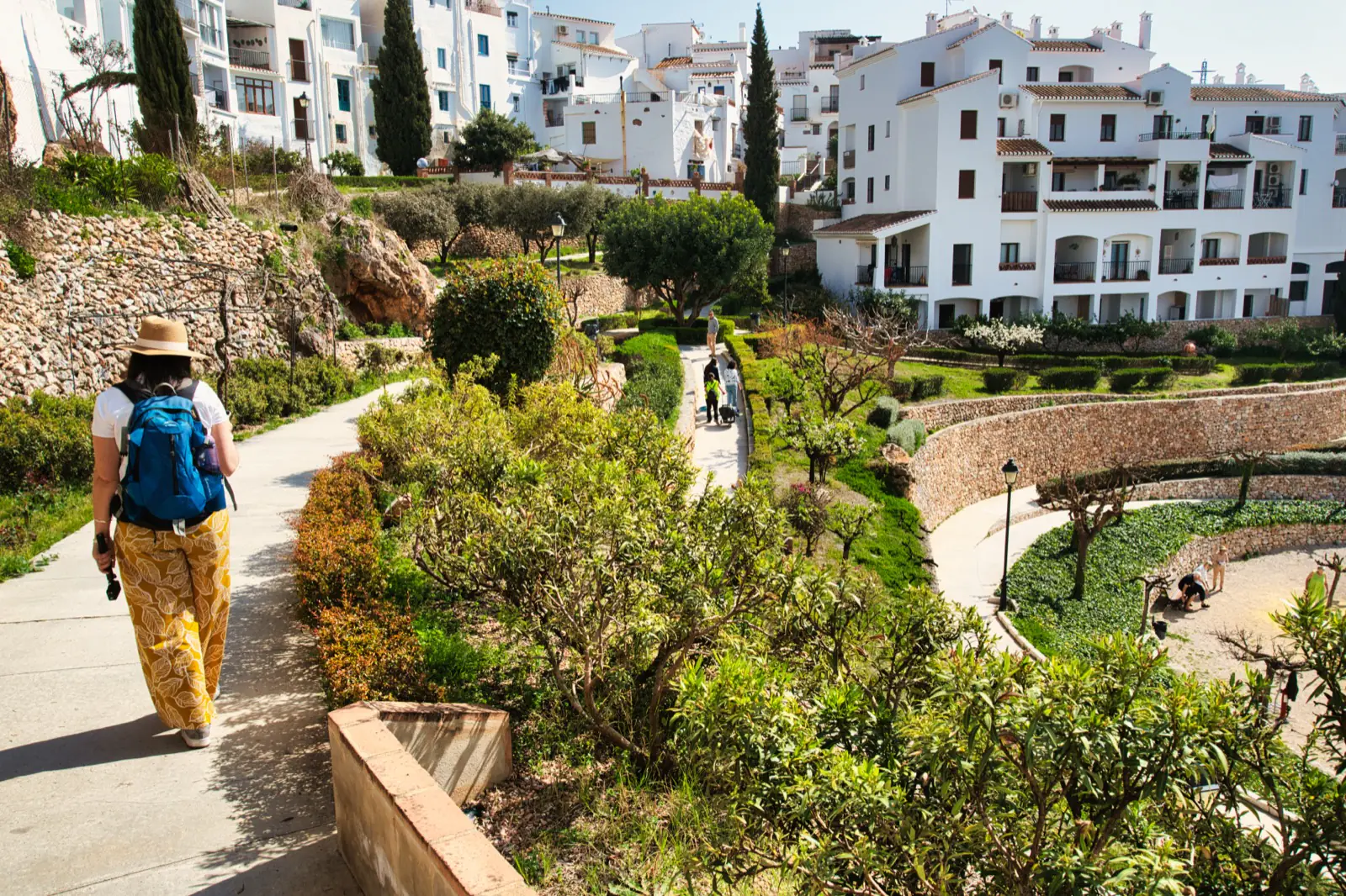 Visitor walking through terraced flower gardens in Frigiliana village