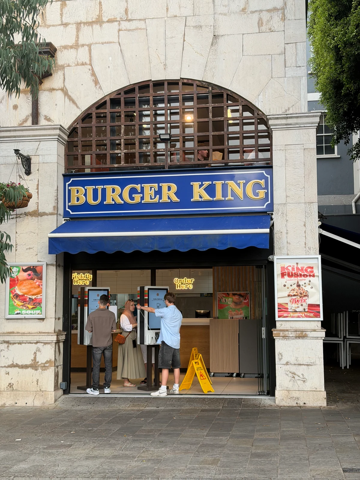 Burger King sign in blue and gold on an arched stone building in Gibraltar