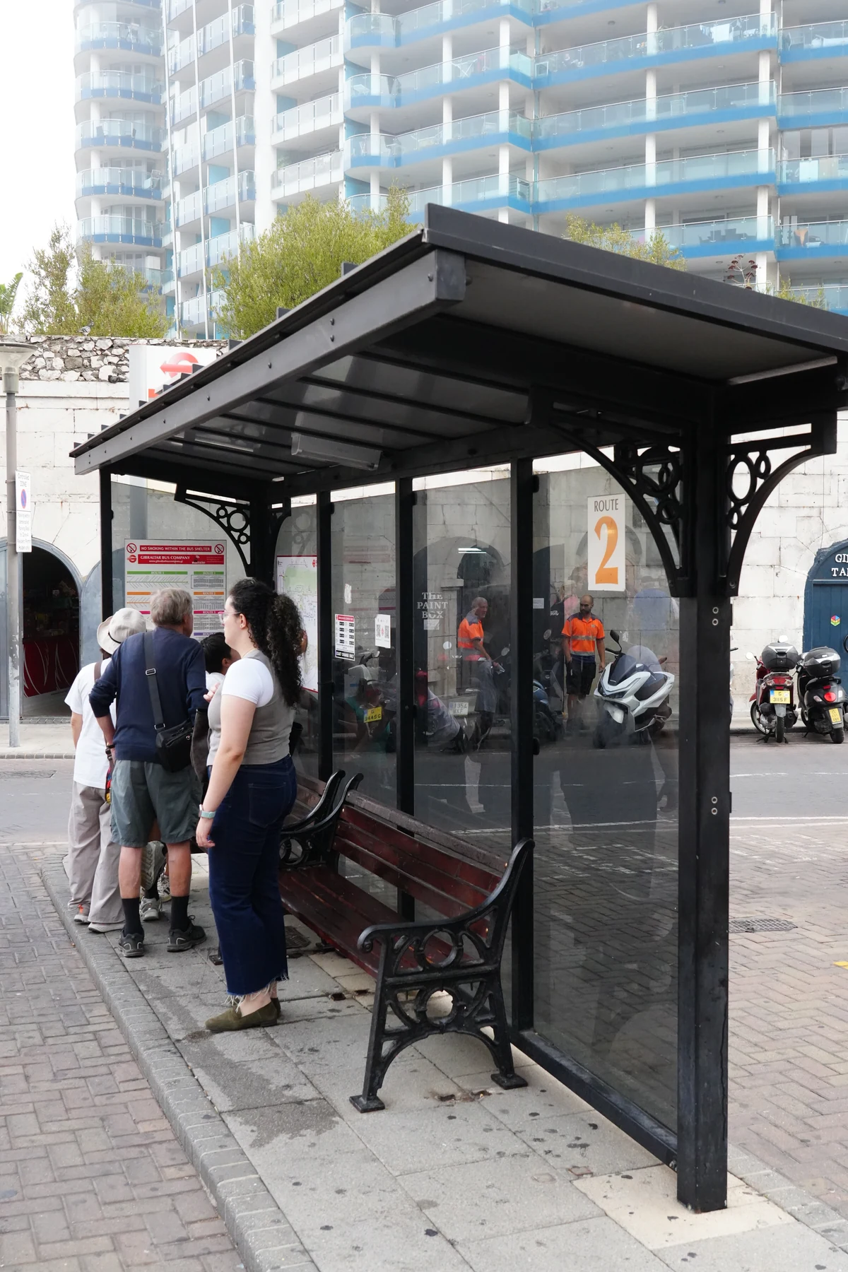 Passengers waiting at a bus stop shelter in Gibraltar