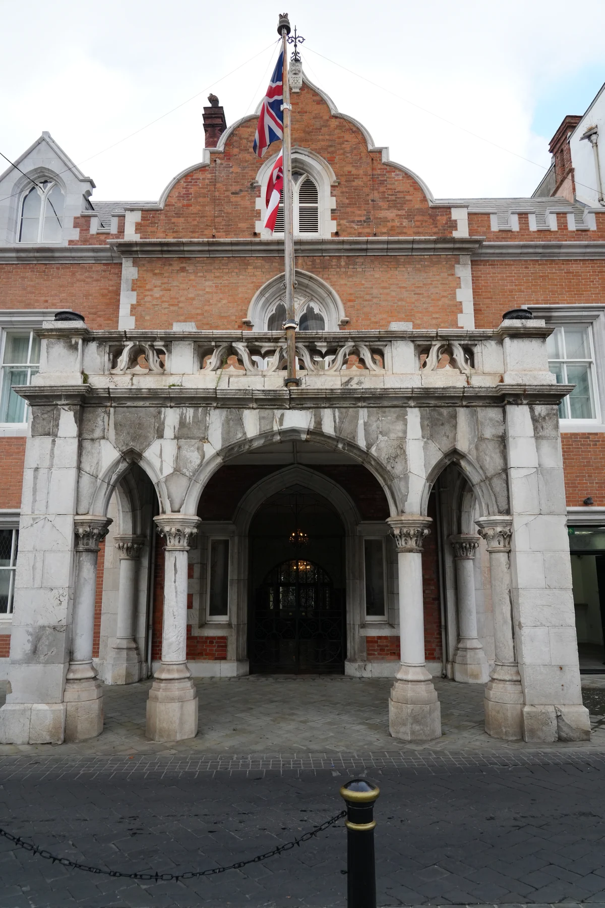 Union Jack flying beside a gothic portico in Gibraltar