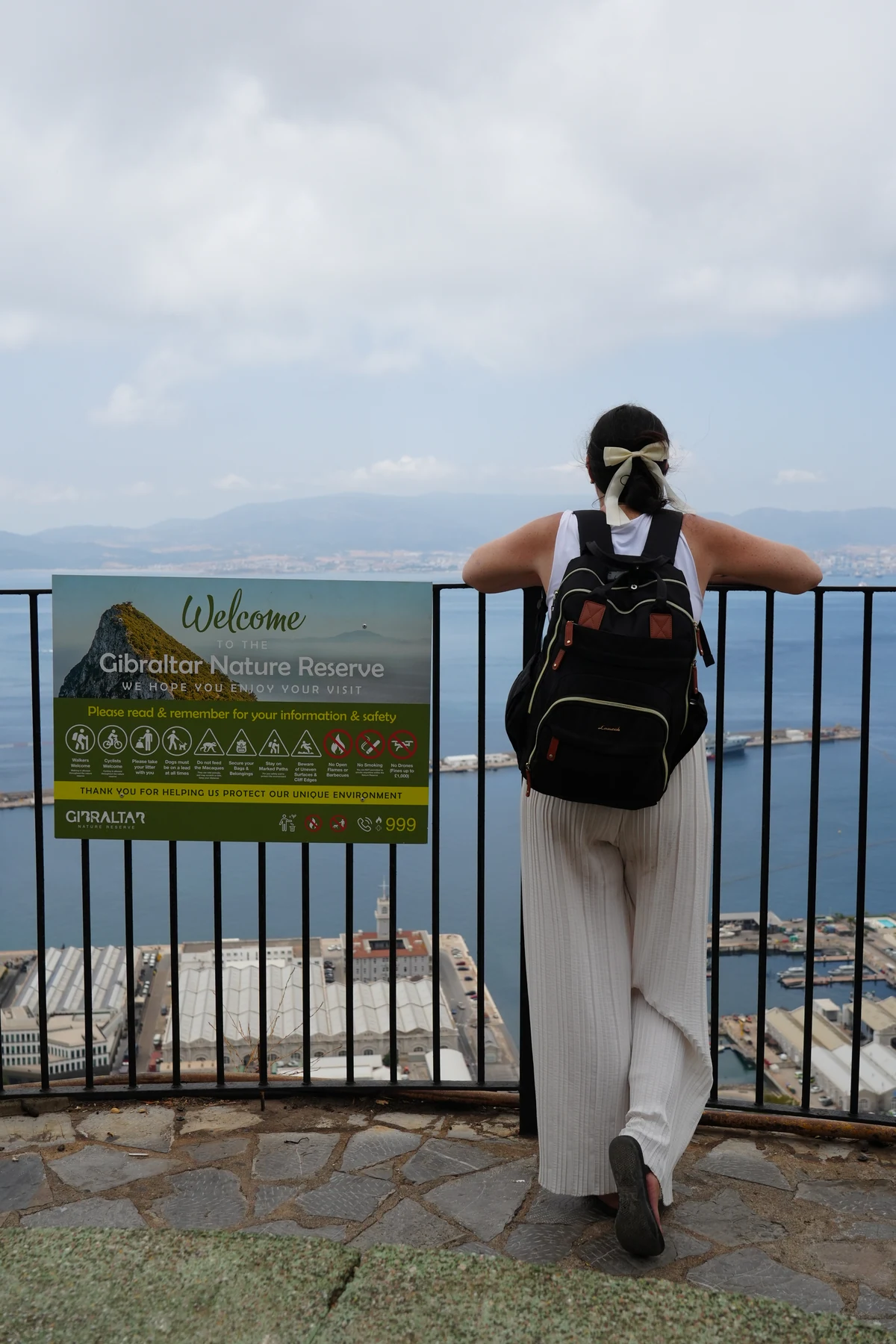 Standing beside the Upper Rock Nature Reserve welcome sign in Gibraltar