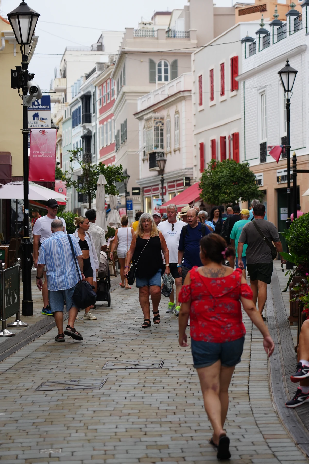 Shoppers below painted facades on Main Street in Gibraltar