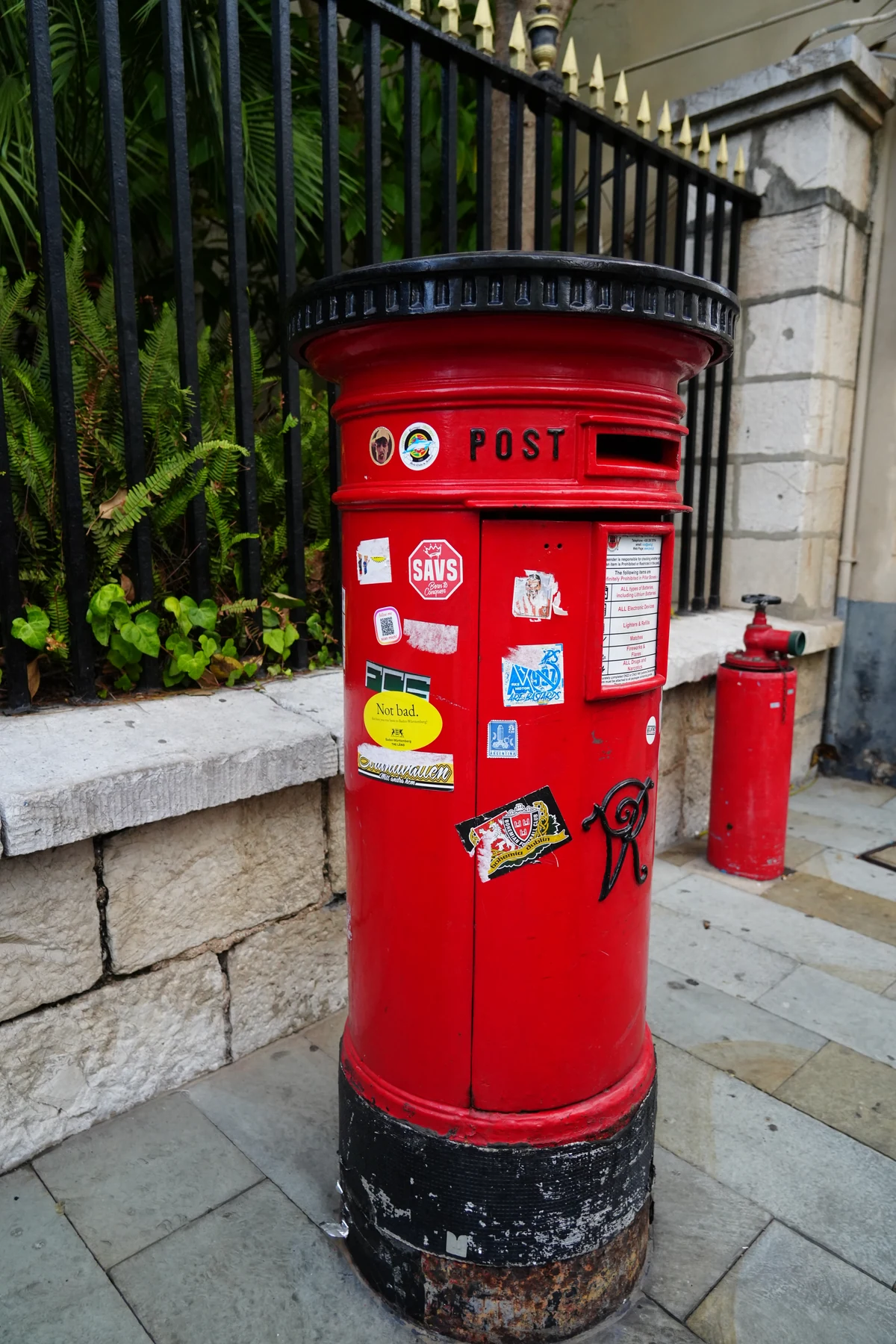 Red pillar post box on a street in Gibraltar