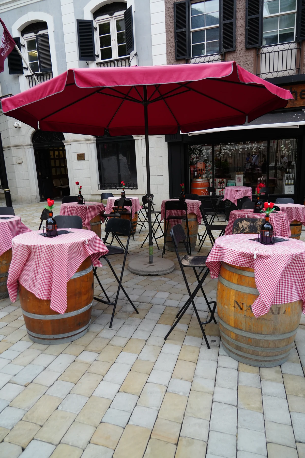 Wine barrel tables under pink parasols outside a bar in Gibraltar