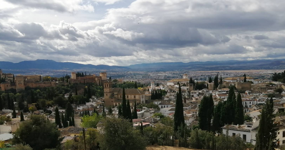 Whitewashed Albaicin rooftops with the Alhambra rising across the valley
