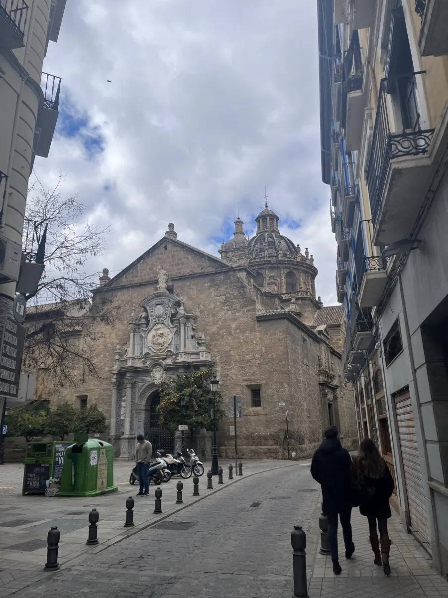 The Basílica de San Juan de Dios, its ornate baroque facade and dome rising above a Granada old town street