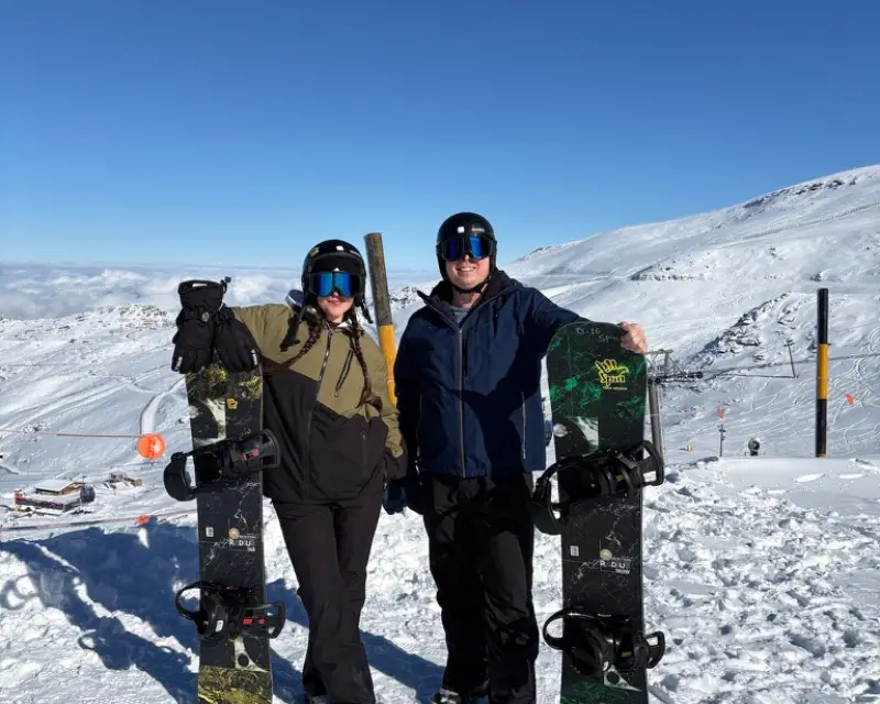 Snow-capped Sierra Nevada mountains with skiers and resort signage