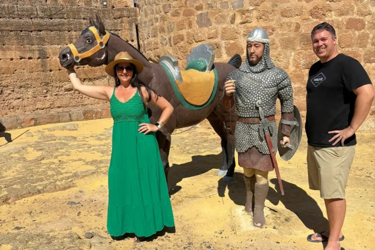 Visitors posing with a medieval knight statue and horse inside Spain's oldest castle