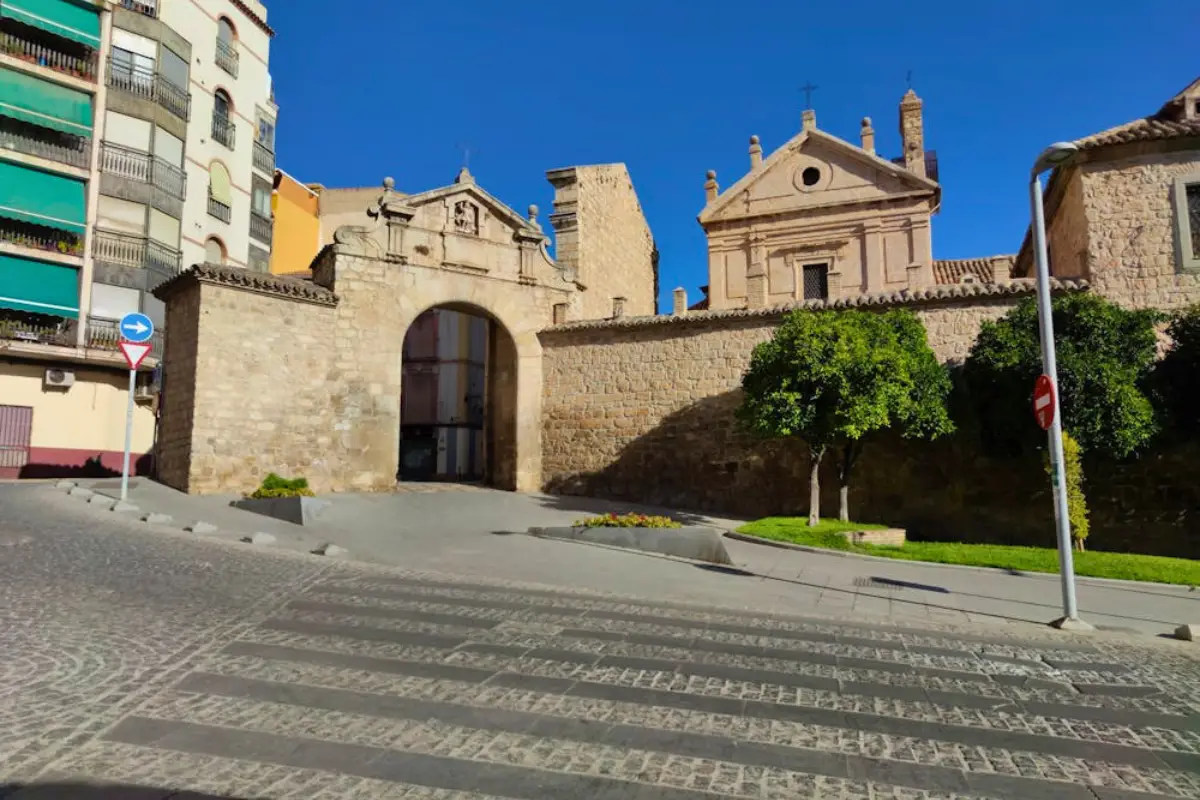 Stone archway and gate leading to a church plaza in Jaén old town