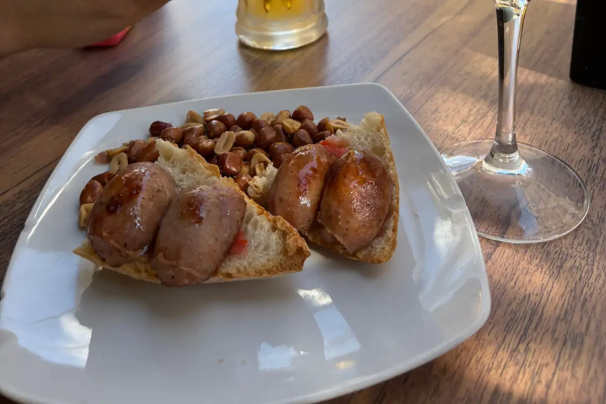 Tapas served with a beer and a sausage roll at a bar in Jaén