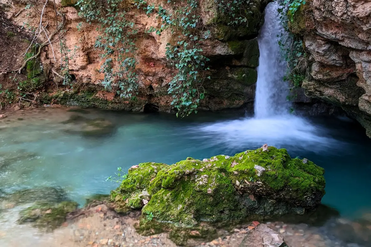 Turquoise waterfall and mossy rock pool in the Sierra de Cazorla