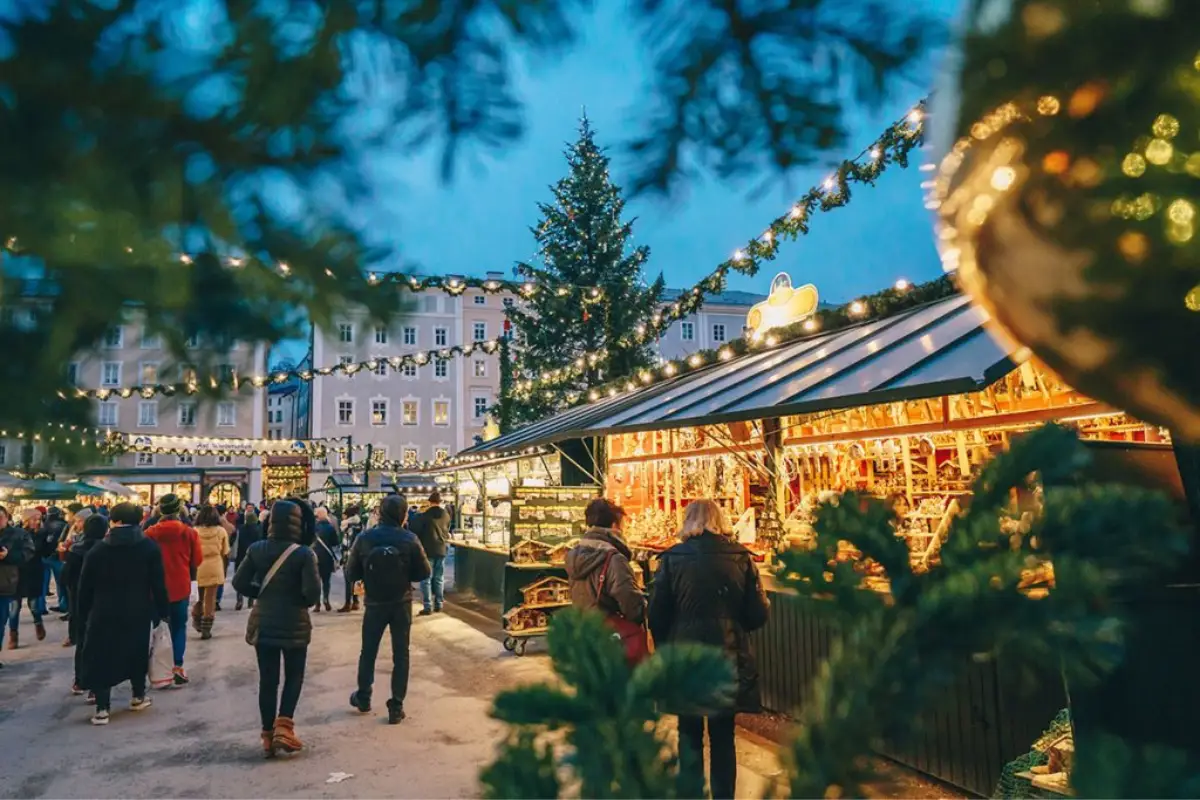 People walking down a street lined with christmas market stalls in Malaga.
