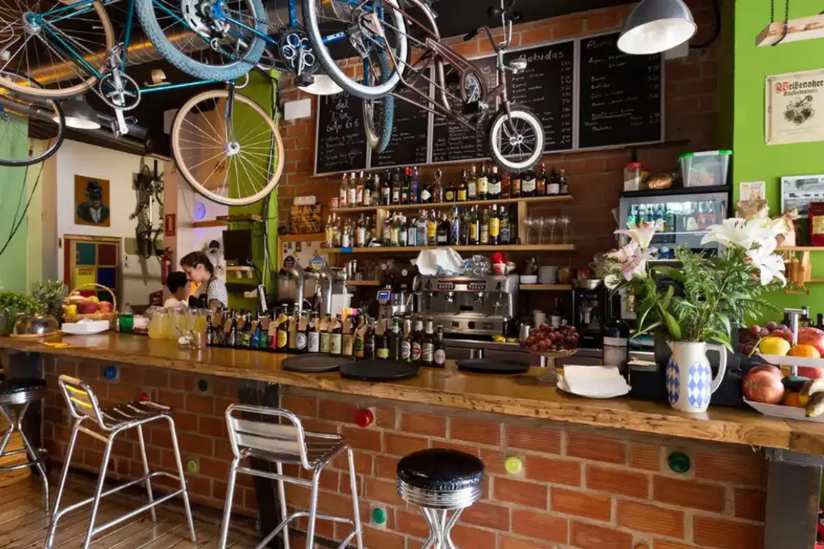 A coffee shop in Malaga with bikes hanging over the bar and a woman taking an order.