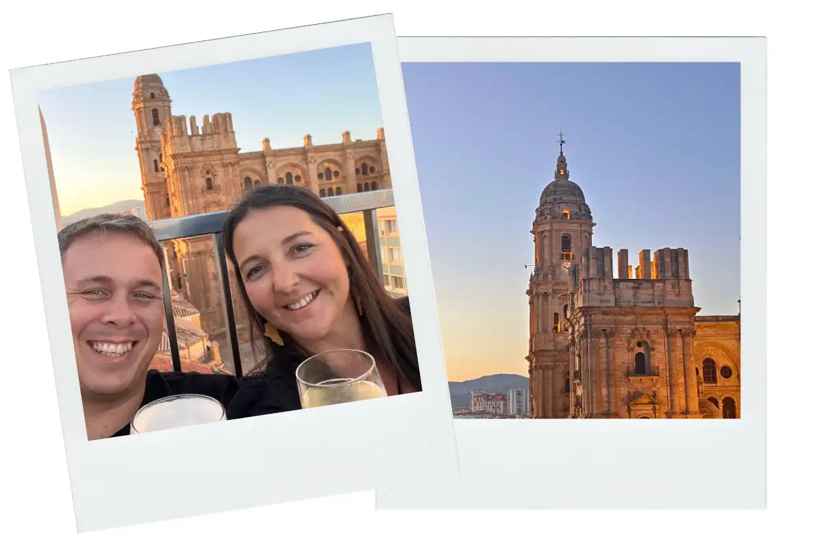A man and a woman smiling holding wine and beer with the Malaga cathedral in the background.