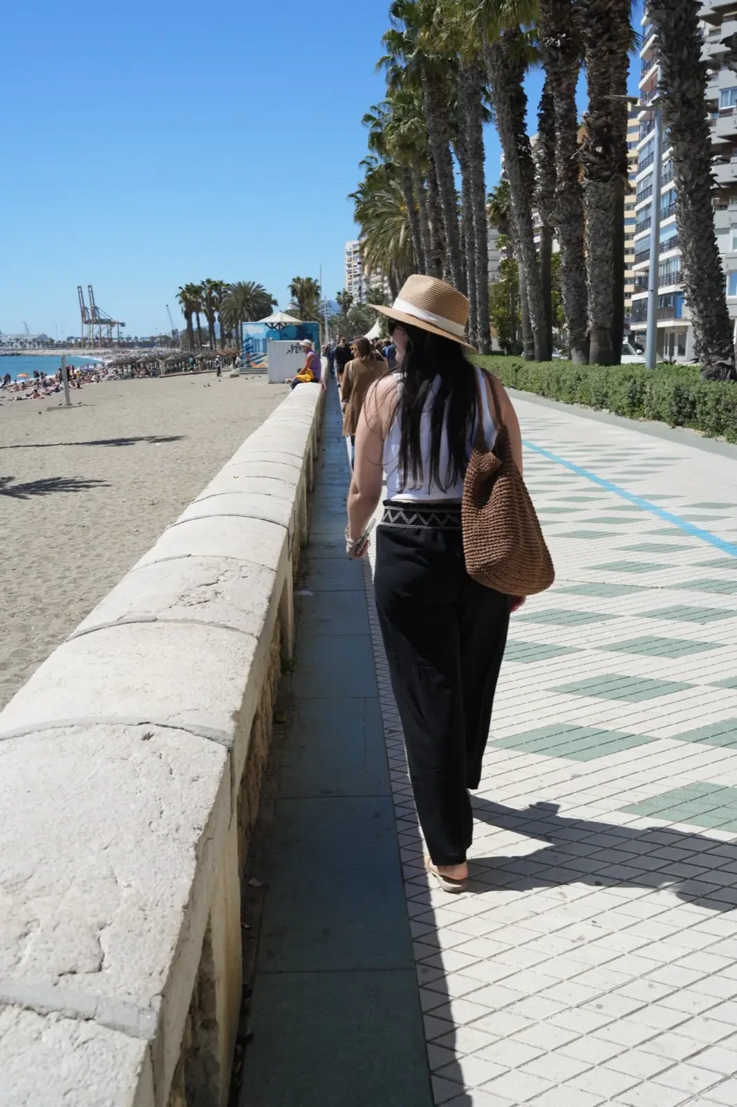 Heidi walking along Malagueta beach promenade on a sunny June morning