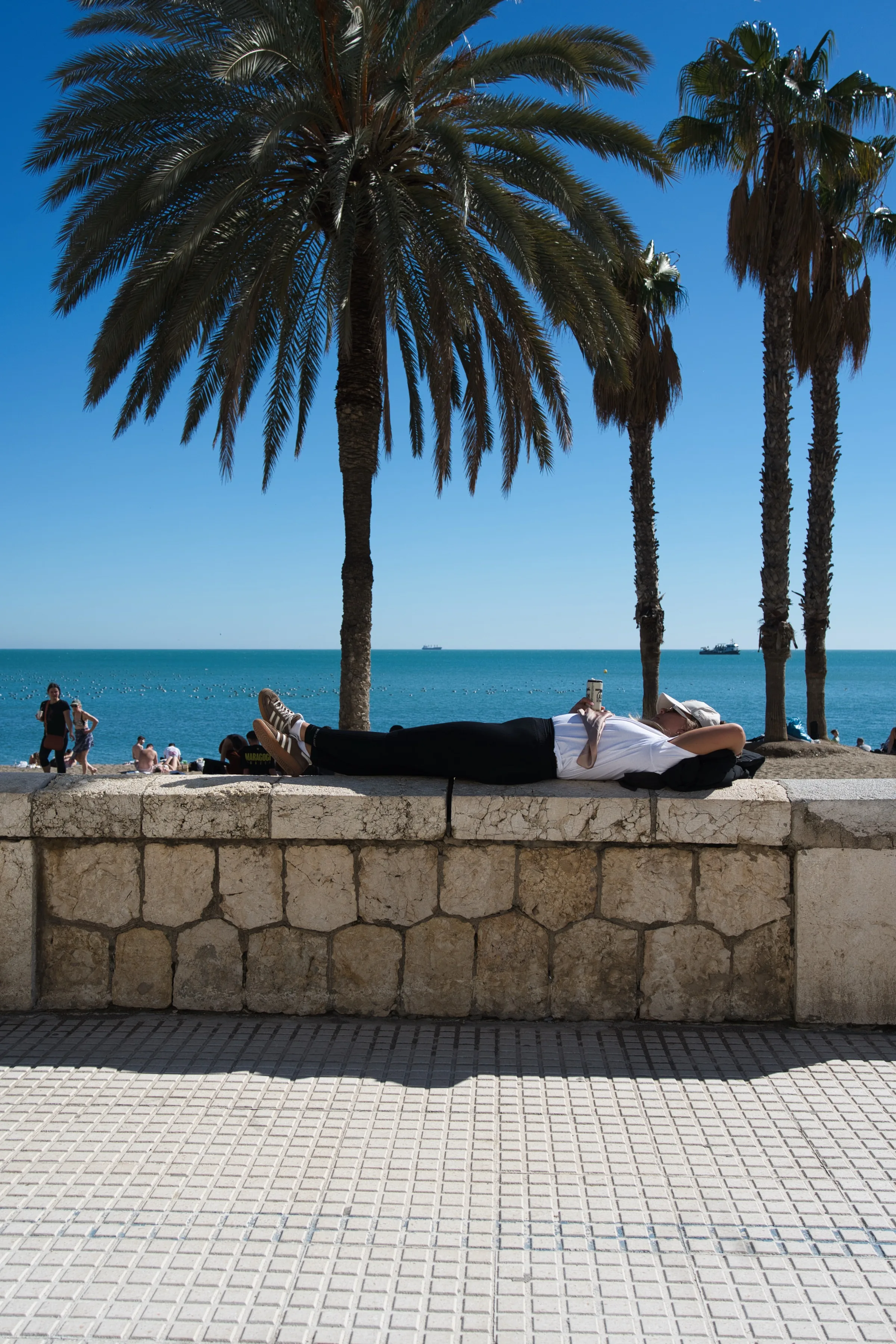 Man relaxing on Playa de la Malagueta on an August morning