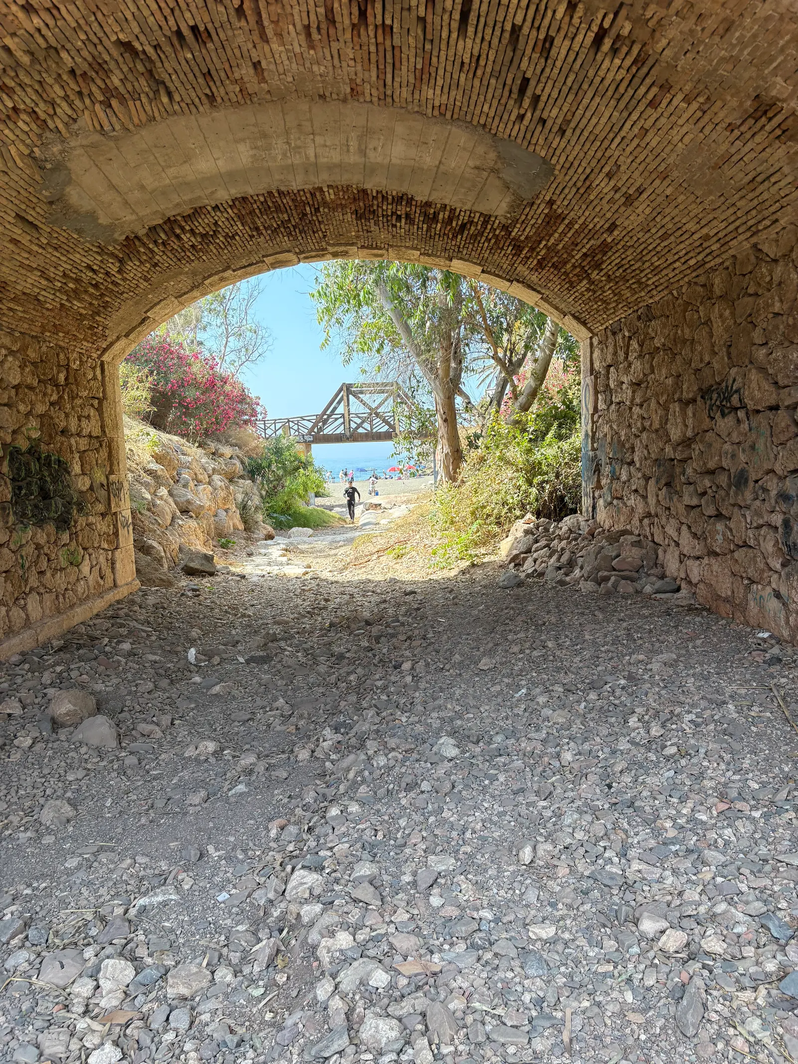 Stone archway on the coastal walkway leading to Playa Peñón del Cuervo