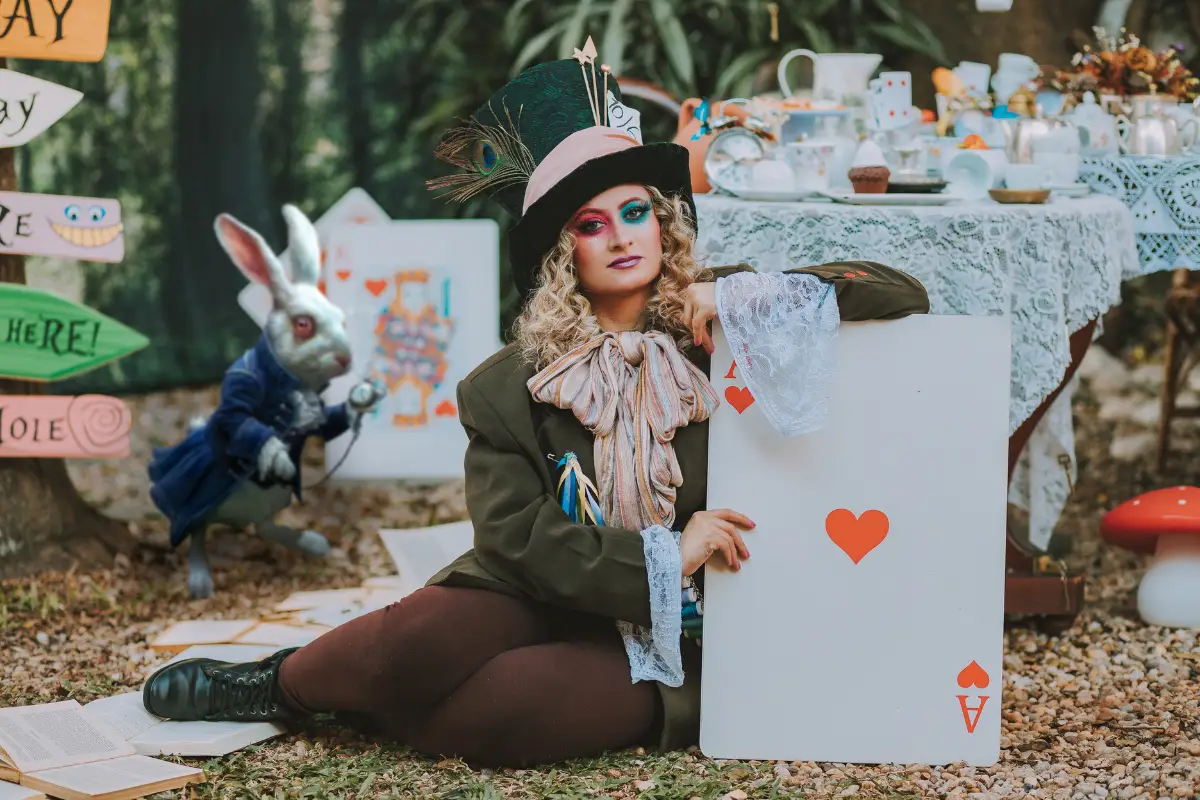 Actress holding a giant ace of spades card at the Alice Christmas event in Malaga's botanical gardens